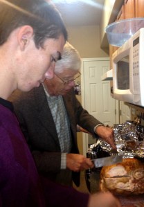 grandpa teaching grandson to carve the bird